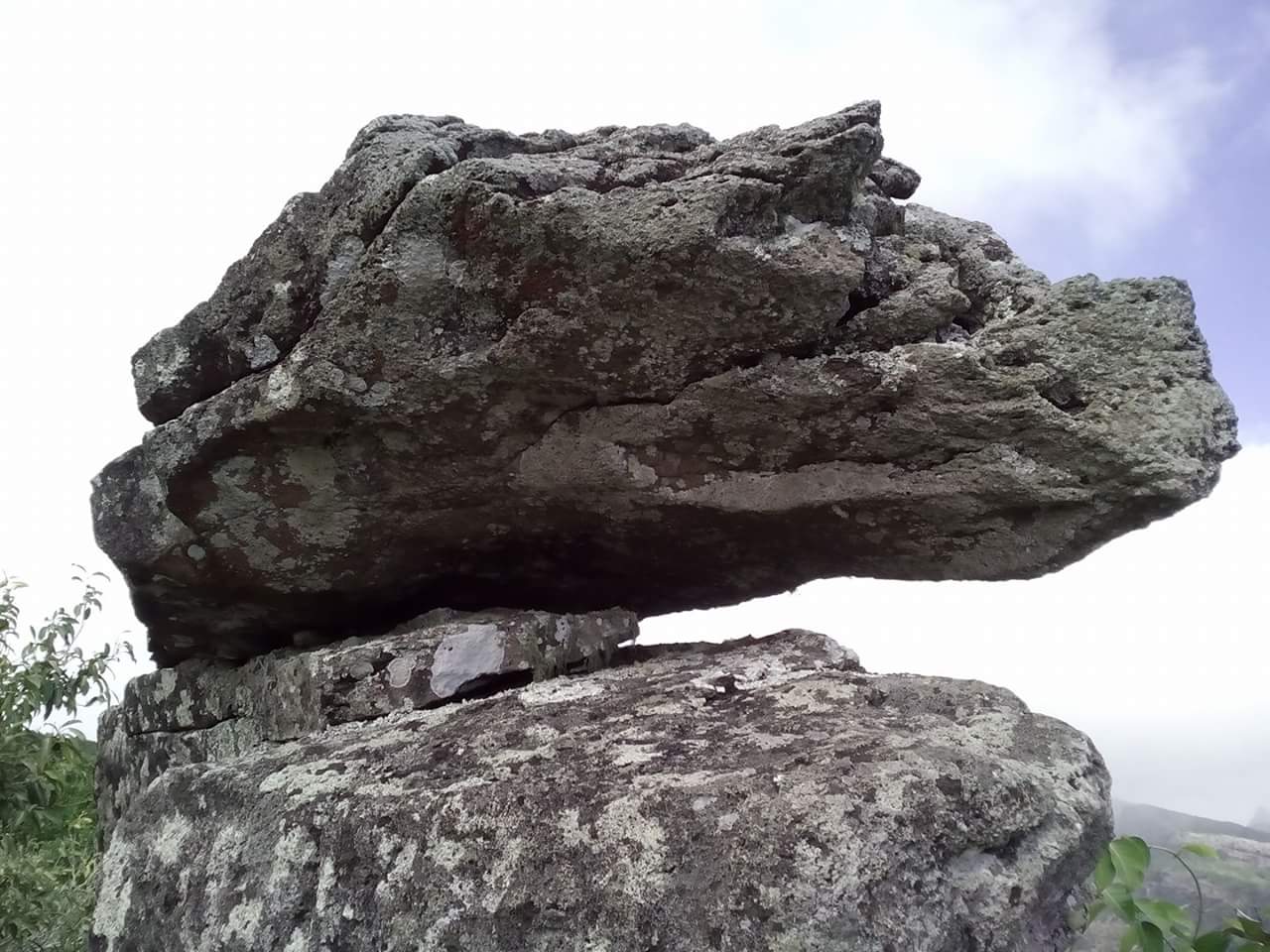 2 grey boulders on top of each other.