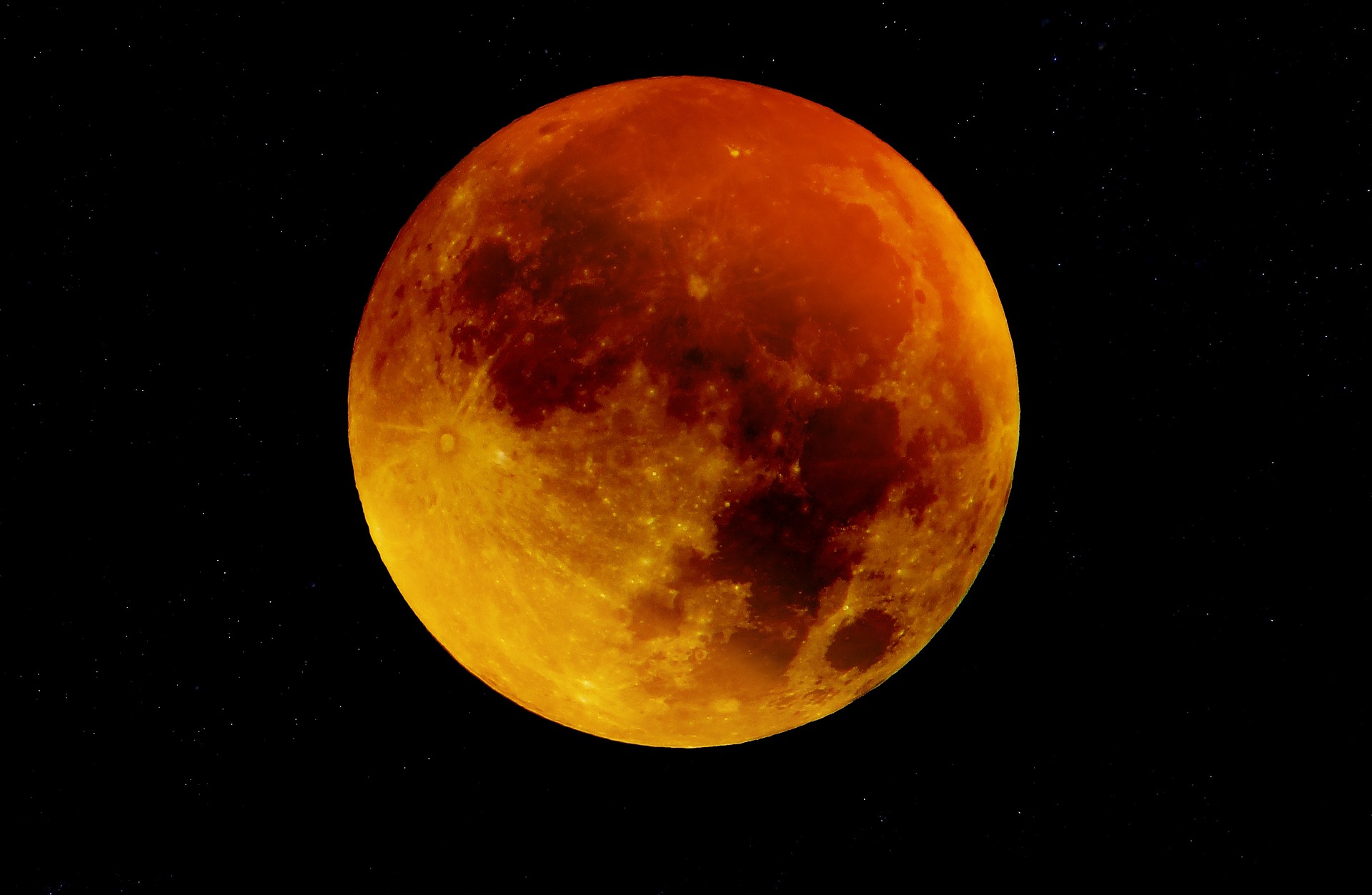 Moon with a yellowish to dark red hue in a black background