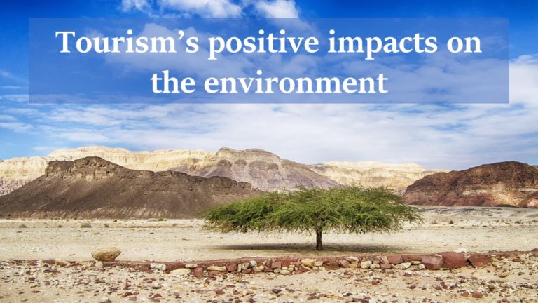 Positive impacts of tourism written on brown mountaineous setting, blue sky backdrop and green tree in the center
