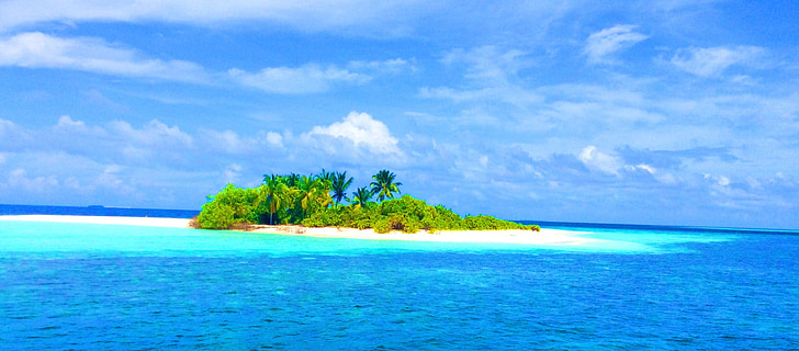 Small offshore islet of mauritius with green trees and white beach in the blue sea