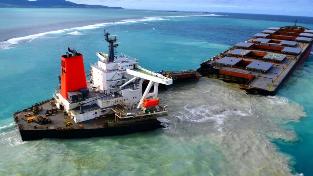 MV Wakashio oil spill in Mauritius; black ship with red chimney broken in two on shallow blue water; ship scuttling (sabordage)