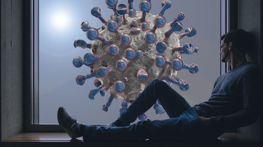 Positive and negative impacts of covid-19, man sitting in front of window with white and blue coronavirus